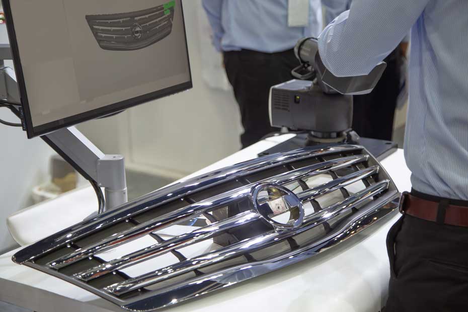 3d grille scanning car grille being 3D scanned next to screen showing the scan data