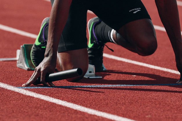 custom sports supports a runner on the starting blocks ready to race